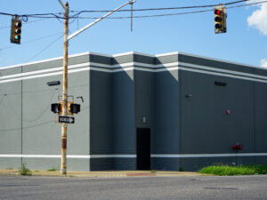 A plan grey building with sharp angles at the corner of an intersection.